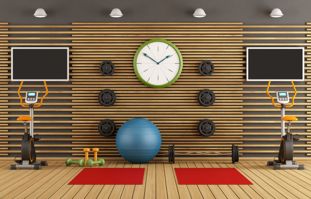 Empty gym with clock on center wall between fitness mats and gym equipment